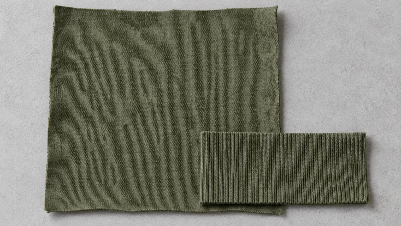 Olive knit body fabric with a rib-knit strip overlapping its edge